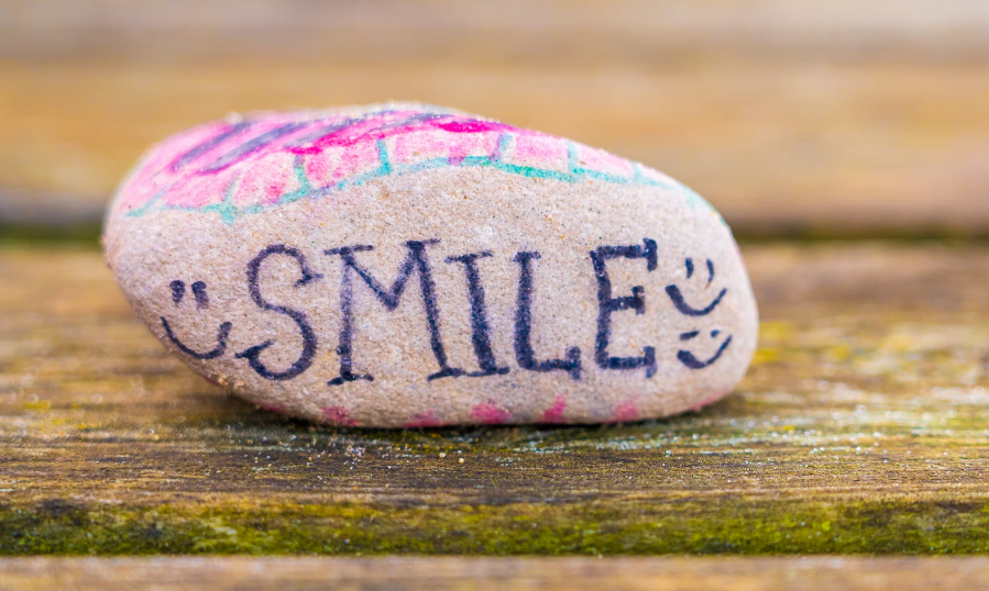 Een Steen Met Het Woord Smile Erop Geschreven, Perfect Voor Een Social Media Campagne.